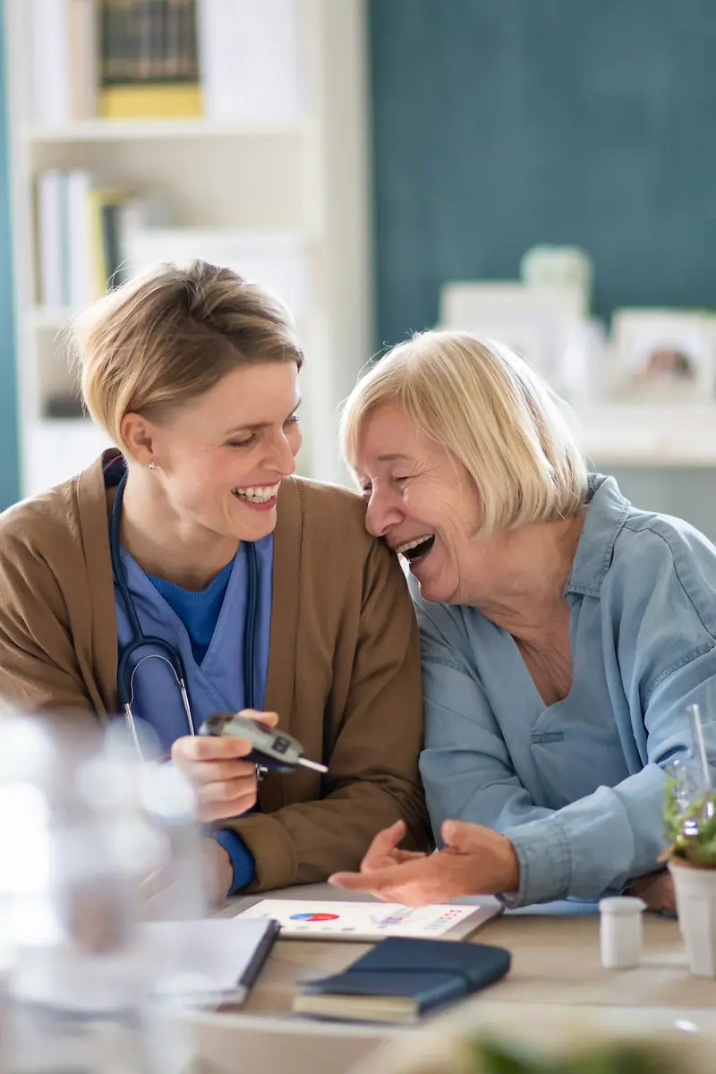 Elderly lady laughing with live in carer